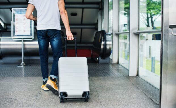 Hombre viaja con maleta en aeropuerto