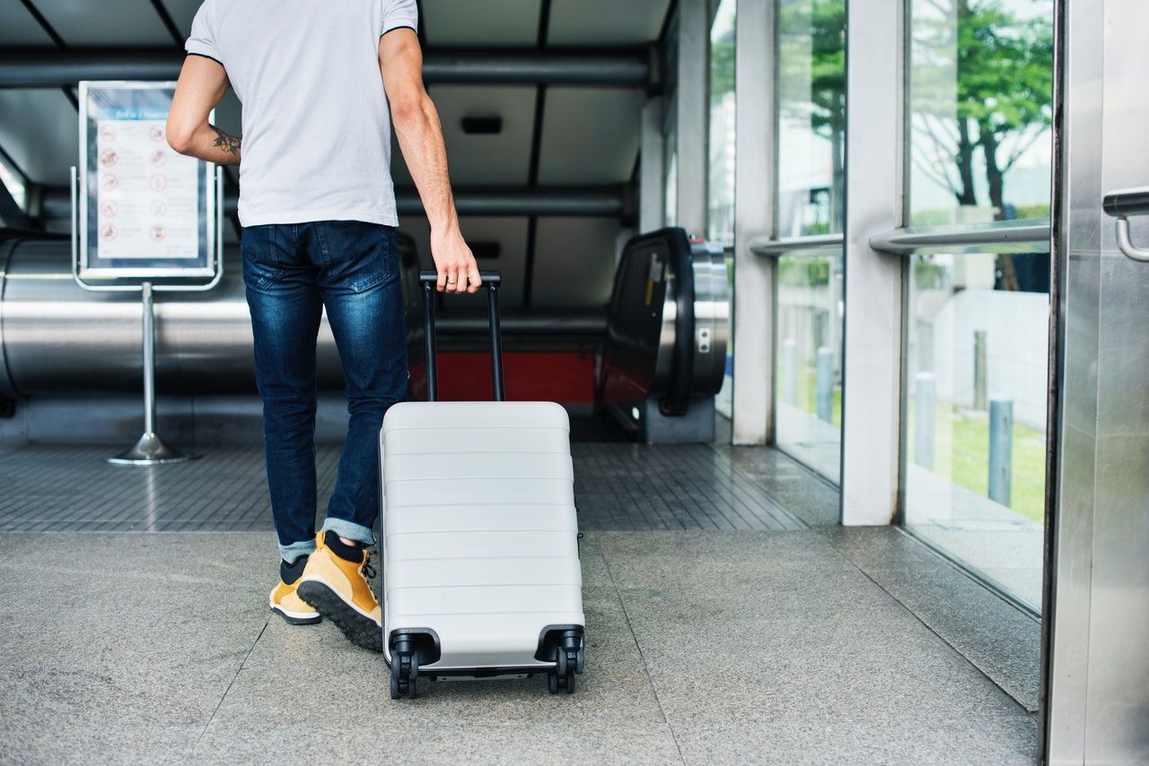 Hombre viaja con maleta en aeropuerto 