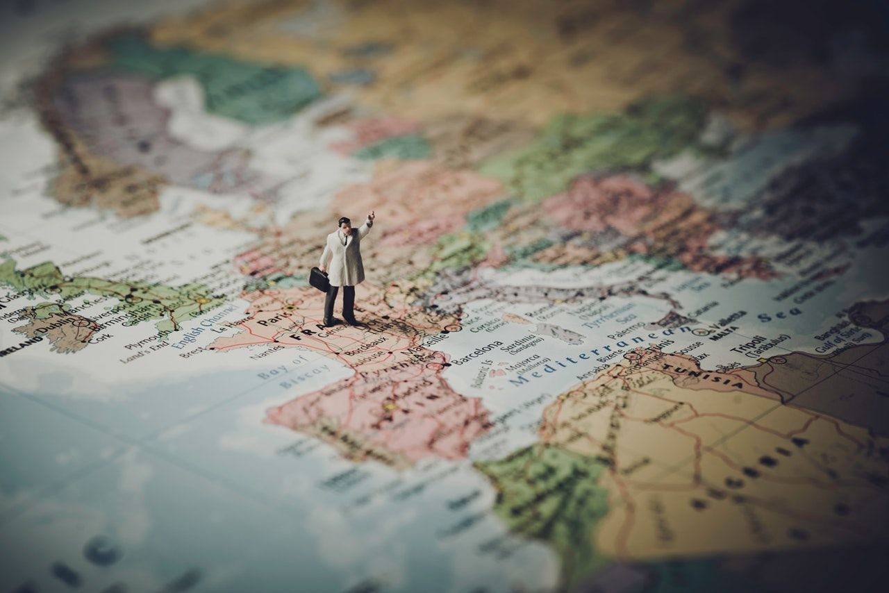 Figura en miniatura de un señor con un maletín sobre un mapa de Europa