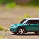miniatura de coche estilo "Mini", de color verde, sobre el suelo exterior