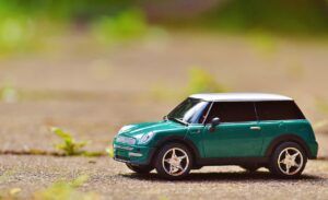 miniatura de coche estilo "Mini", de color verde, sobre el suelo exterior