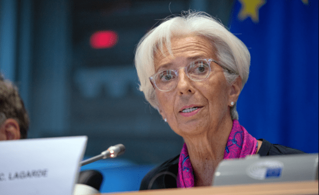 Mujer mayor de pelo claro y gafas con pañuelo rosa al cuello habla a un micrófono en el Parlamento Europeo