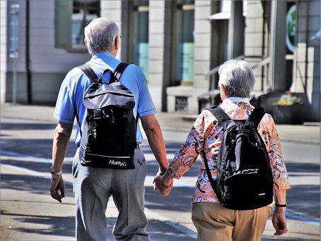 pareja anciana anda cogida de la mano por la ciudad