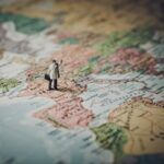 Figura en miniatura de un señor con un maletín sobre un mapa de Europa