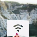 Icono de señal Wifi dibujado en un papel blanco sobre un fondo con paisaje montañoso