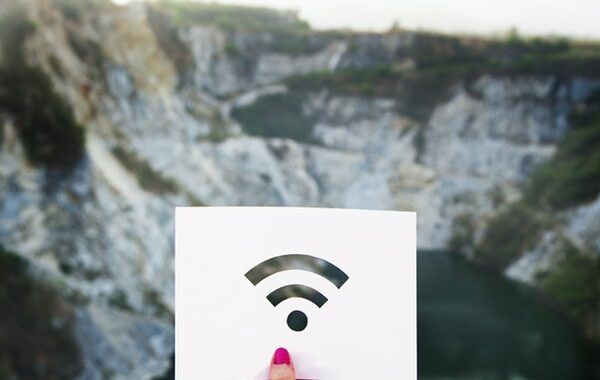 Icono de señal Wifi dibujado en un papel blanco sobre un fondo con paisaje montañoso