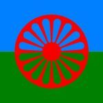 Bnadera compuesta de una franja verde abajo y una azul claro arriba con una rueda de carromato roja en el centro