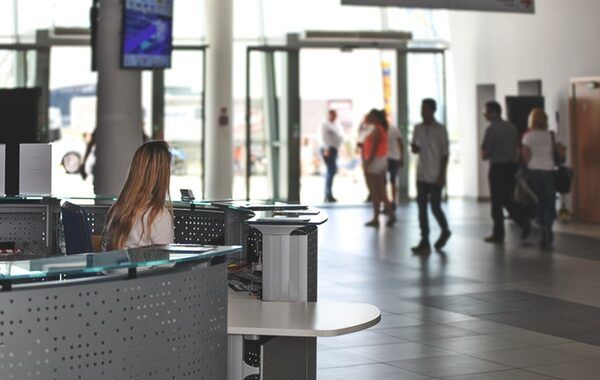 Mujer atiendo en el mostrador de atención al cliente de un aeropuerto