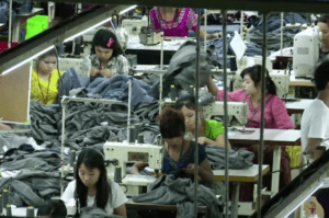 Mujeres asiáticas trabajan en una fábrica de costura en condiciones desfavorables