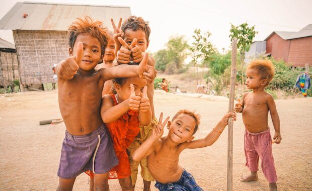 niños asiáticos delgados y sin camiseta sonríen a la cámara y posan