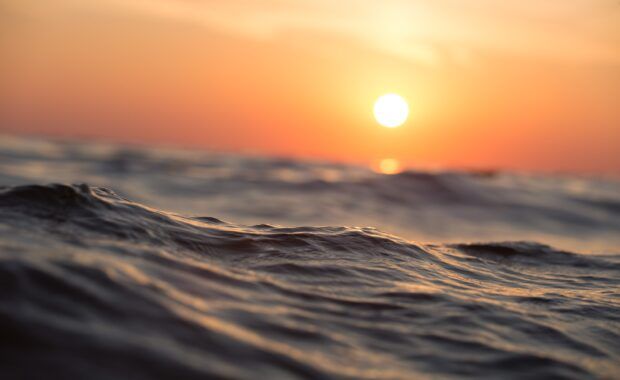 ola en el mar con puesta de sol