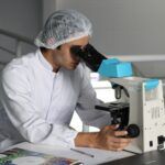 investigador mirando a través de un microscopio