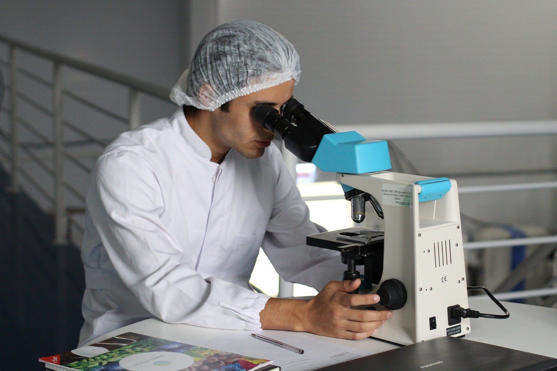 investigador mirando a través de un microscopio