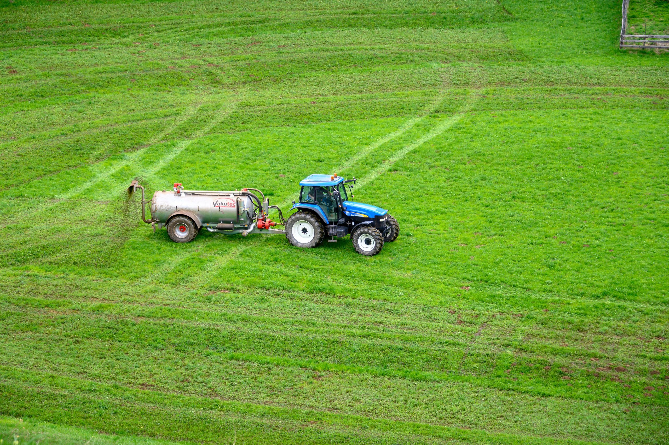 tractor con fertilizante en campo verde