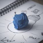 papel azul arrugado sobre dibujo de una bombilla
