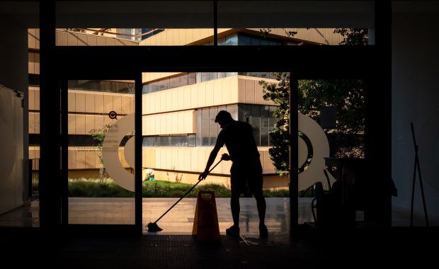 Personal de limpieza fregando el suelo de un edificio