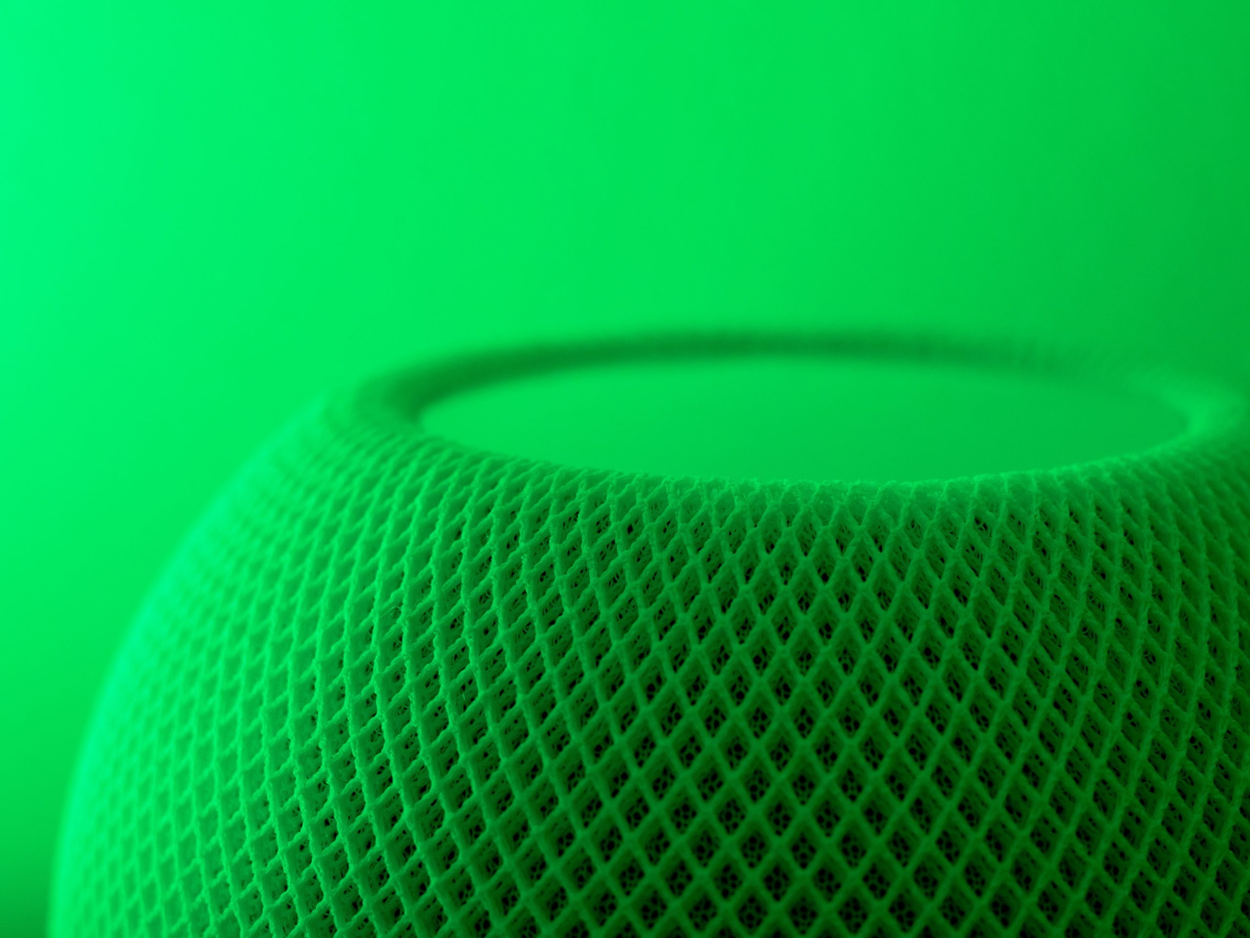 Detalle de un micrófono verde sobre un fondo del mismo color