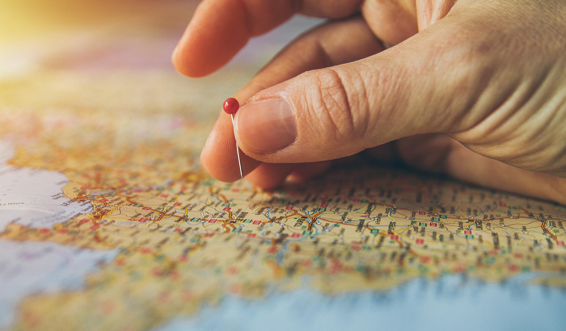 marking world map with a drawing pin