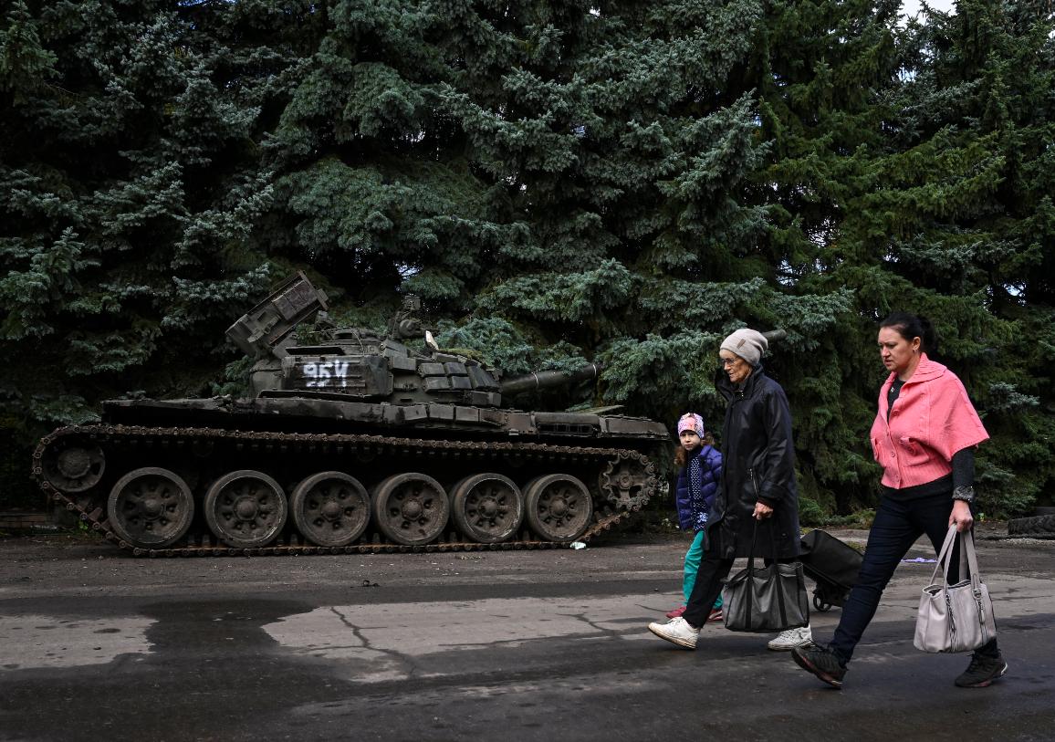 refugiados de ucrania con un tanque por atras