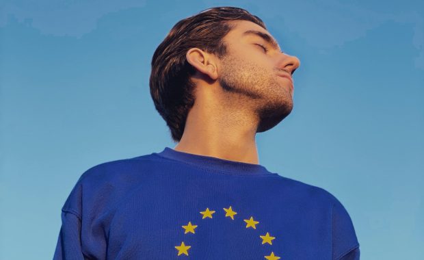 Un joven viste una sudadera que representa la bandera de la Unión Europea