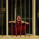 Mujer árabe grita tras los barrotes de una prisión
