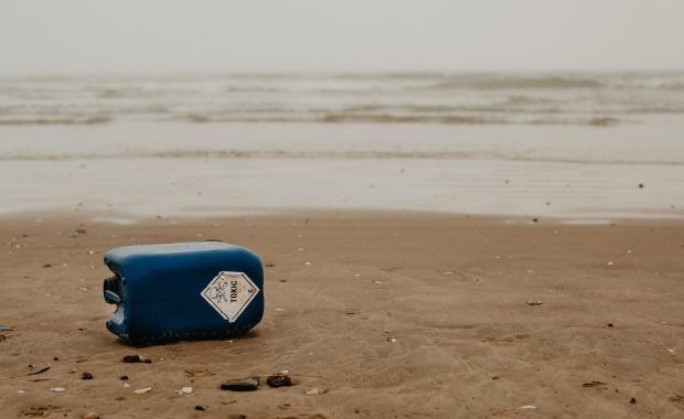 envase de plástico en la arena de la playa