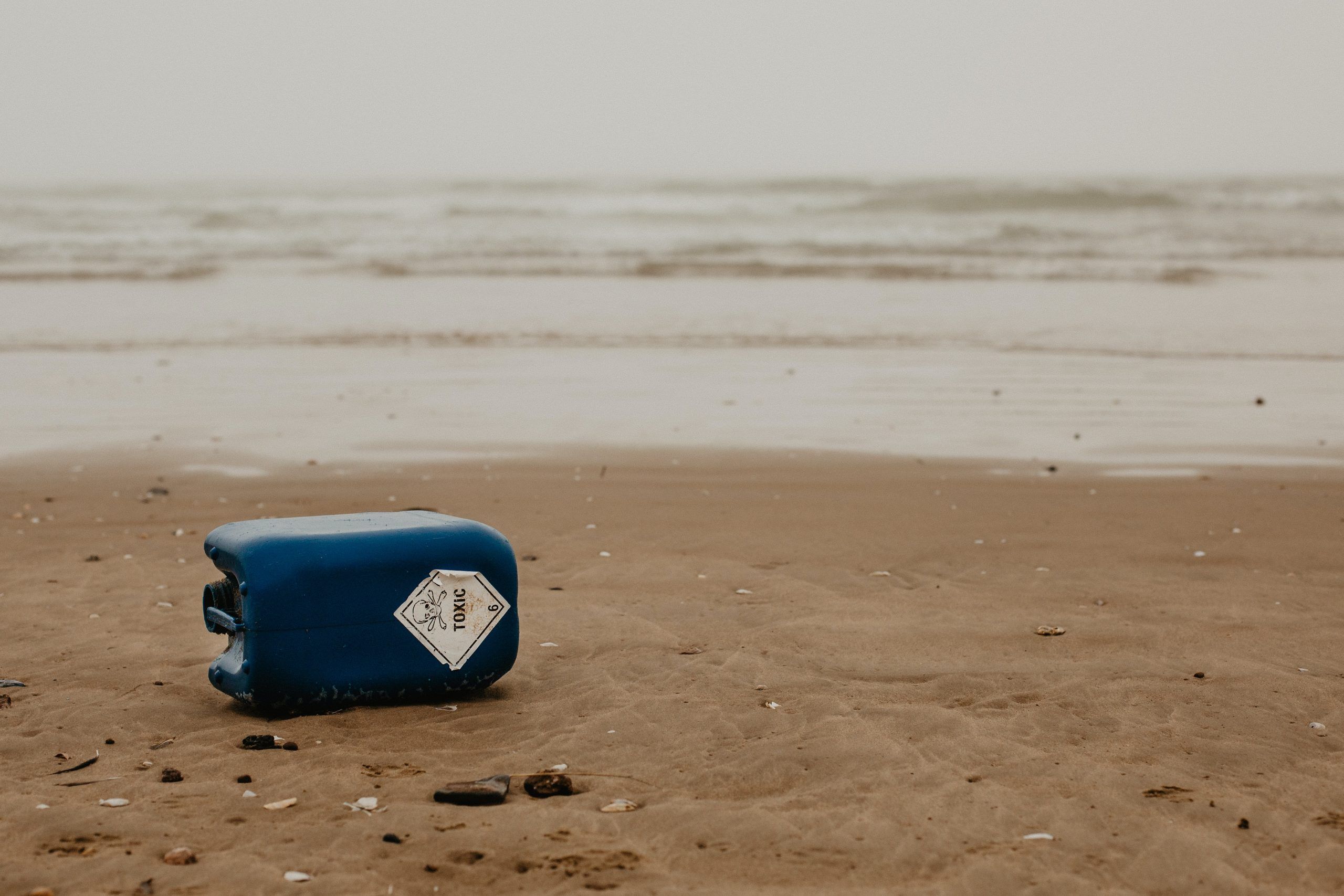 envase de plástico en la arena de la playa