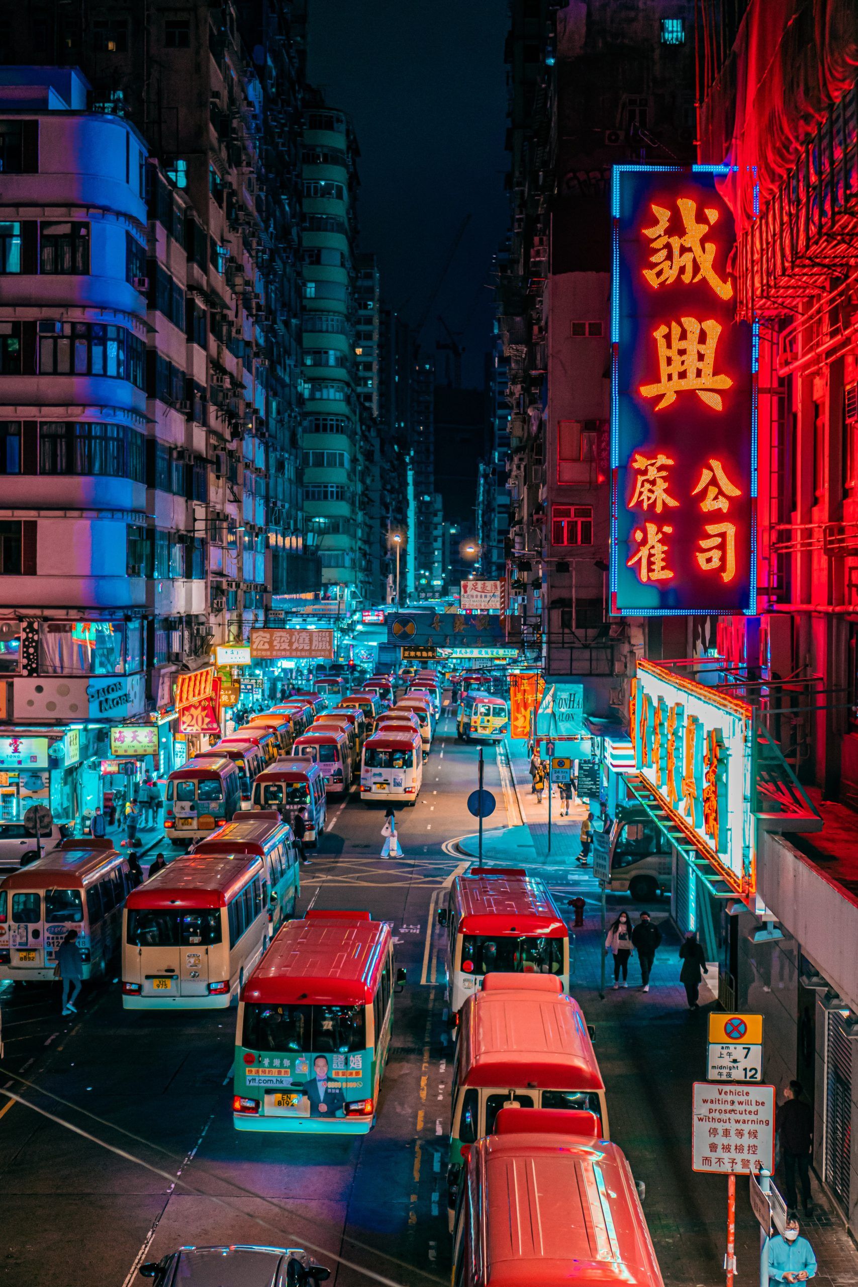 Vista nocturna de una calle de Hong Kong repleta de carteles luminosos y luces de neón de distintos colores