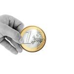 Mano en blanco y negro sujeta una moneda de un euro de gran tamaño y a color