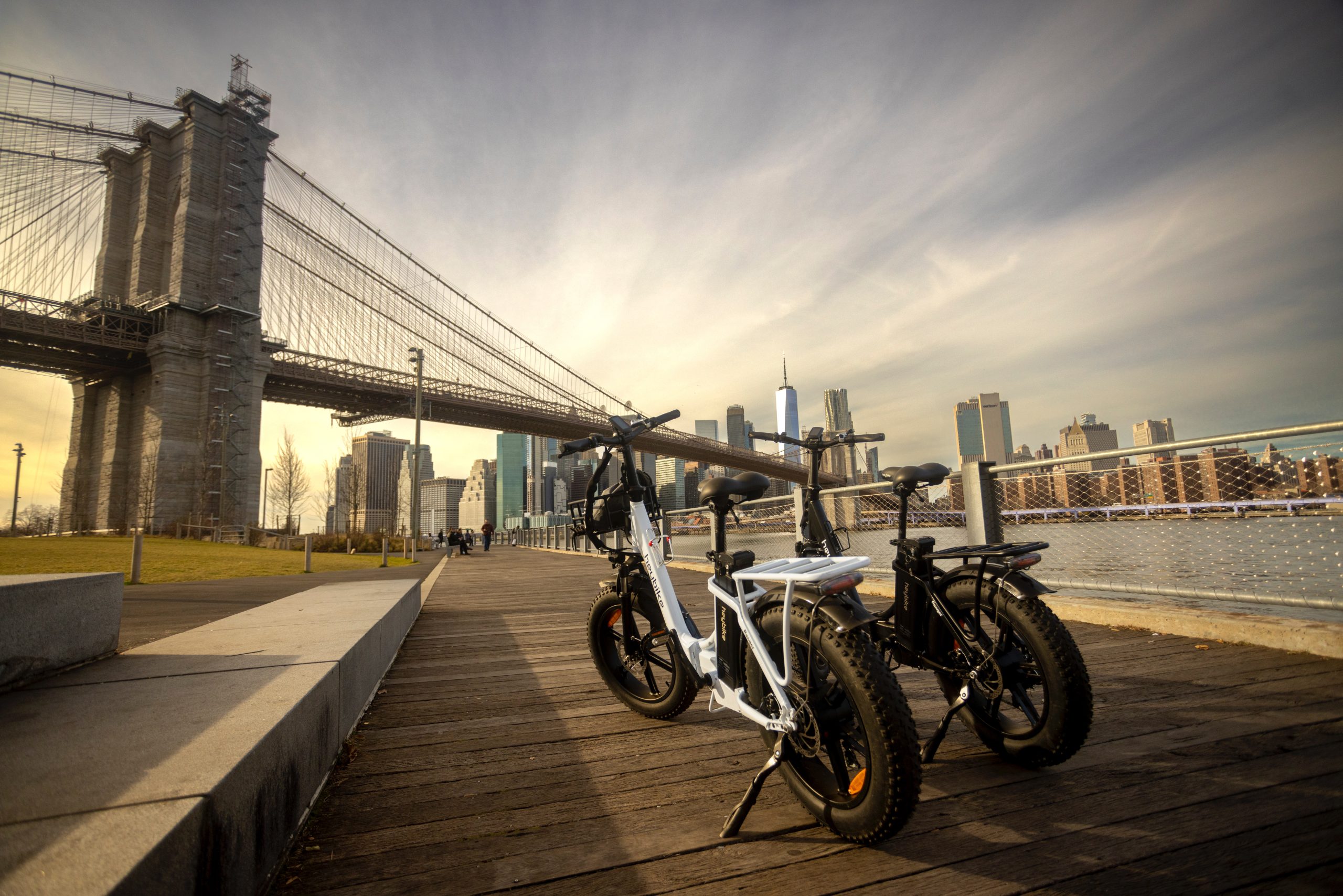 Dos bicicletas eléctricas paradas frente a un gran puente