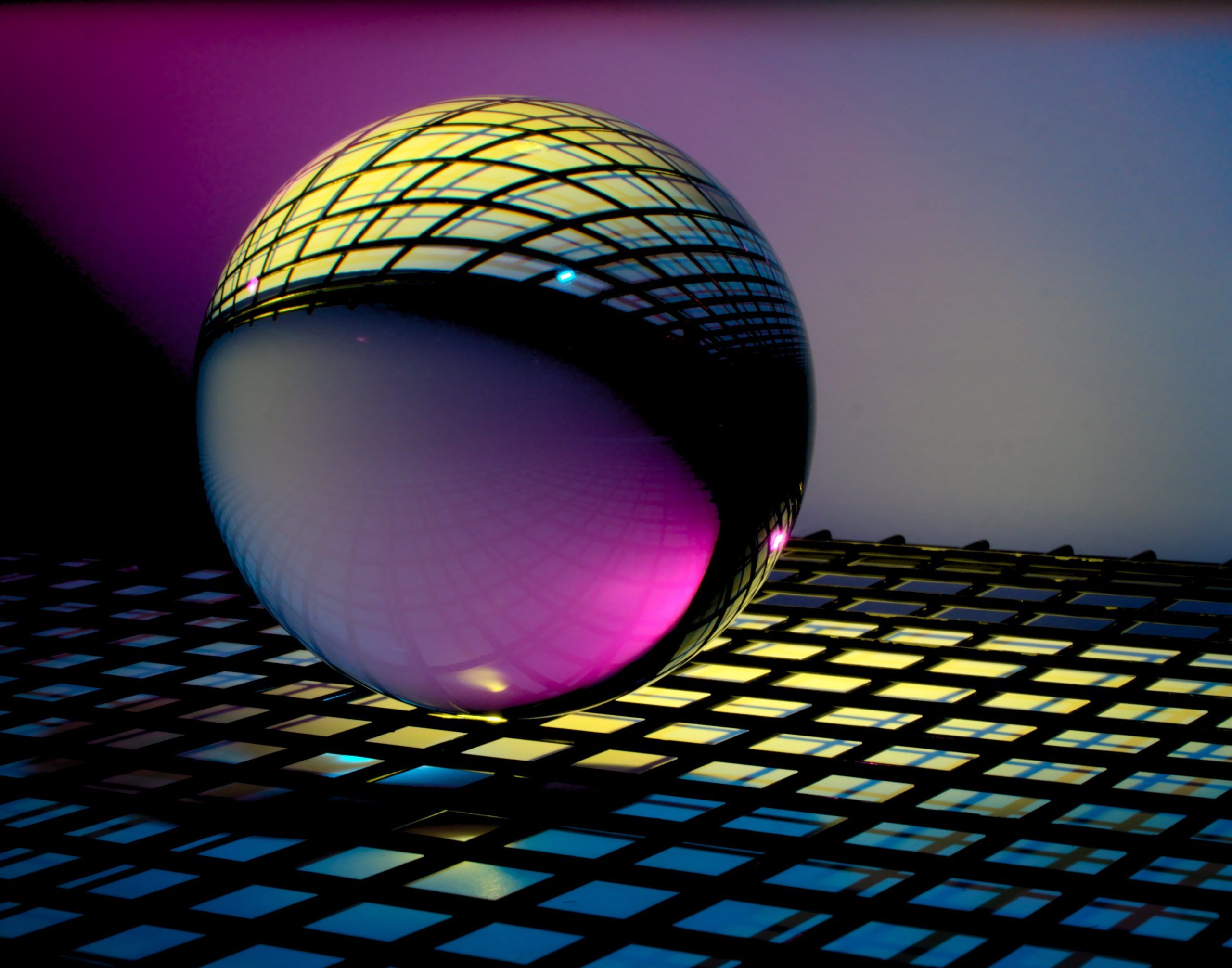 Dibujo digital de una esfera transparente sobre un fondo de rejilla a través de la que se filtra luz amarilla