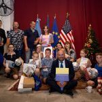 grupo de adultos y niños con regalos y banderas de Europa y EEUU