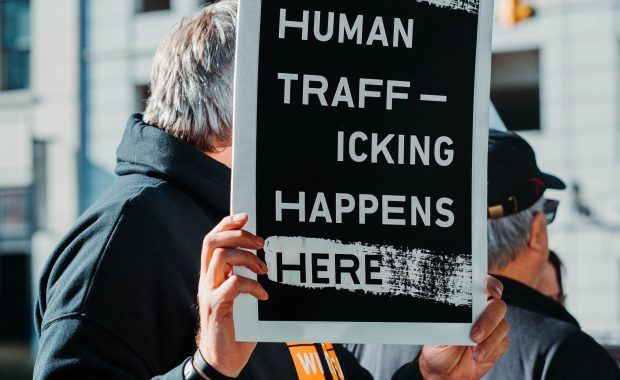 Hombre sujetando cartel Tráfico Humano
