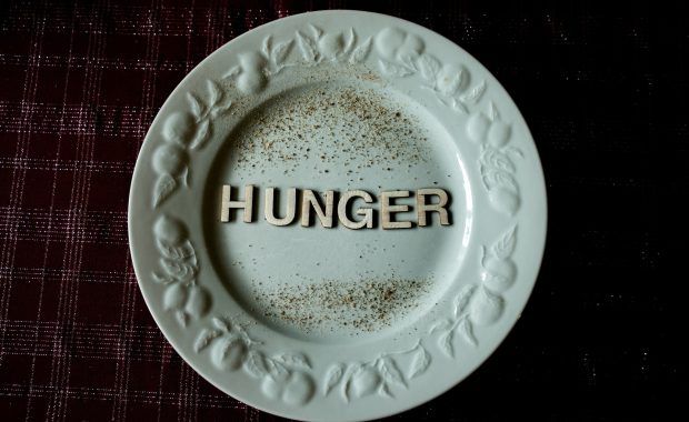 Plato vacío en el que reposan letras que forman la palabra "Hunger", 'hambre' en inglés
