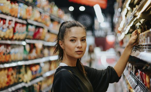 Primer plano de una mujer que mira a cámara en un supermercado