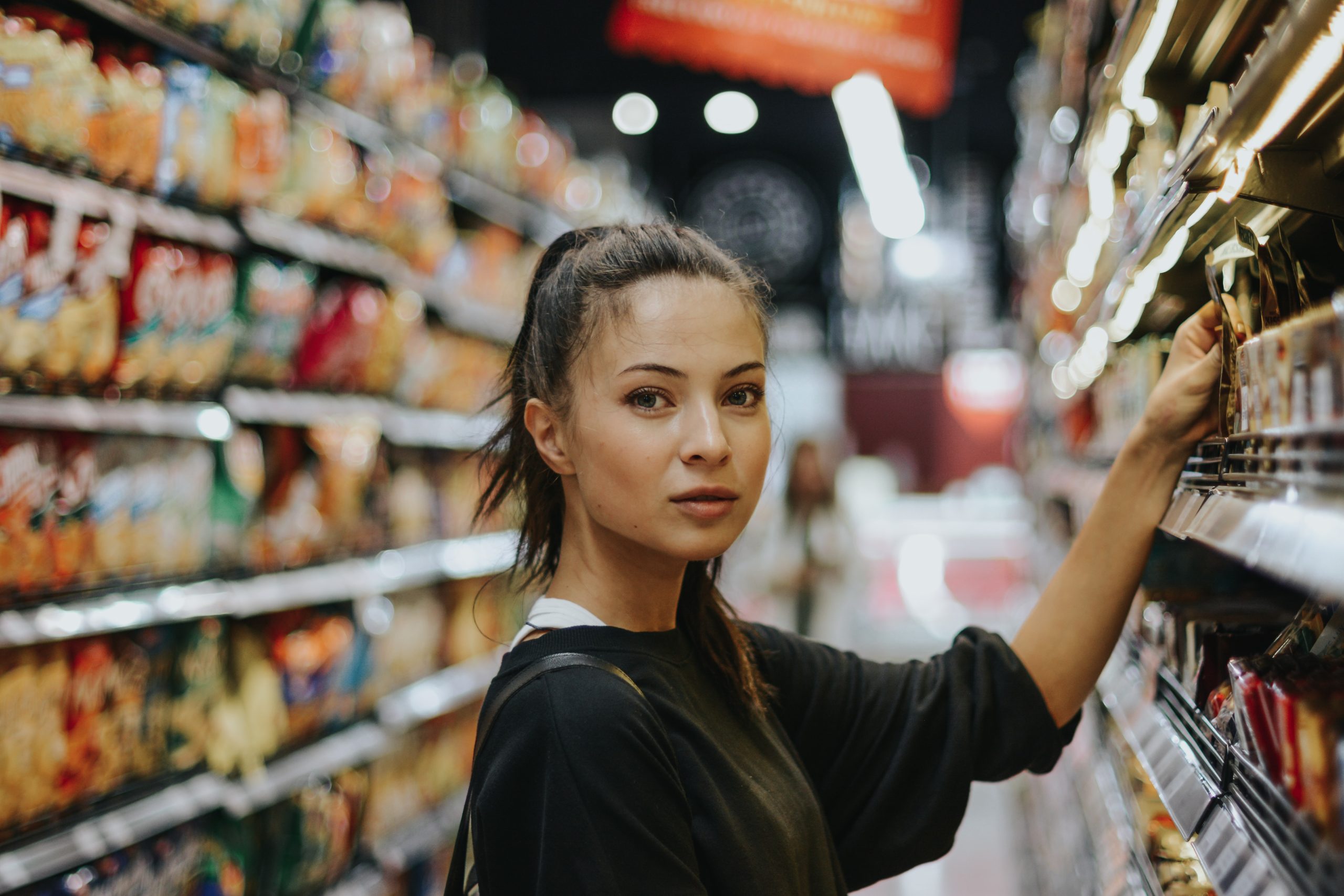 Primer plano de una mujer que mira a cámara en un supermercado