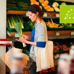 Mujer comprando puerros en un supermercado