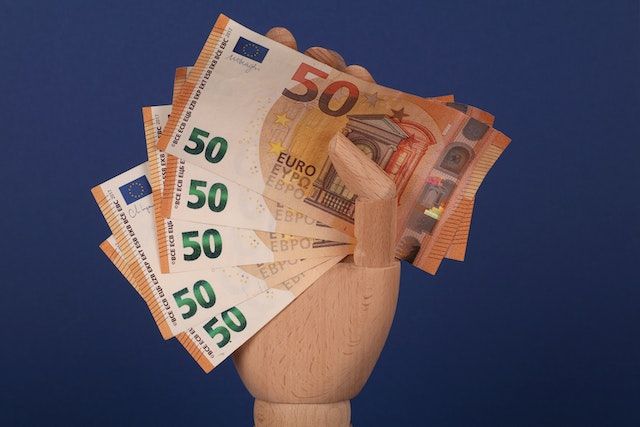mano de madera con billetes de 50 euros