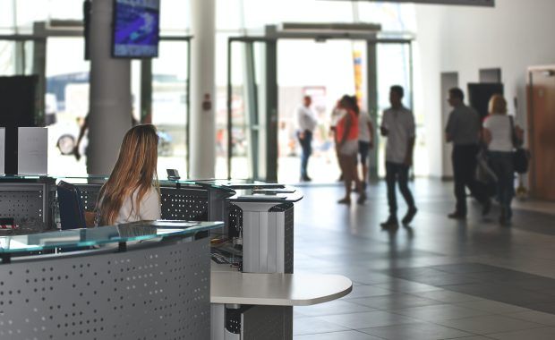 secretaria mirando a gente en la entrada del edificio desde en interior