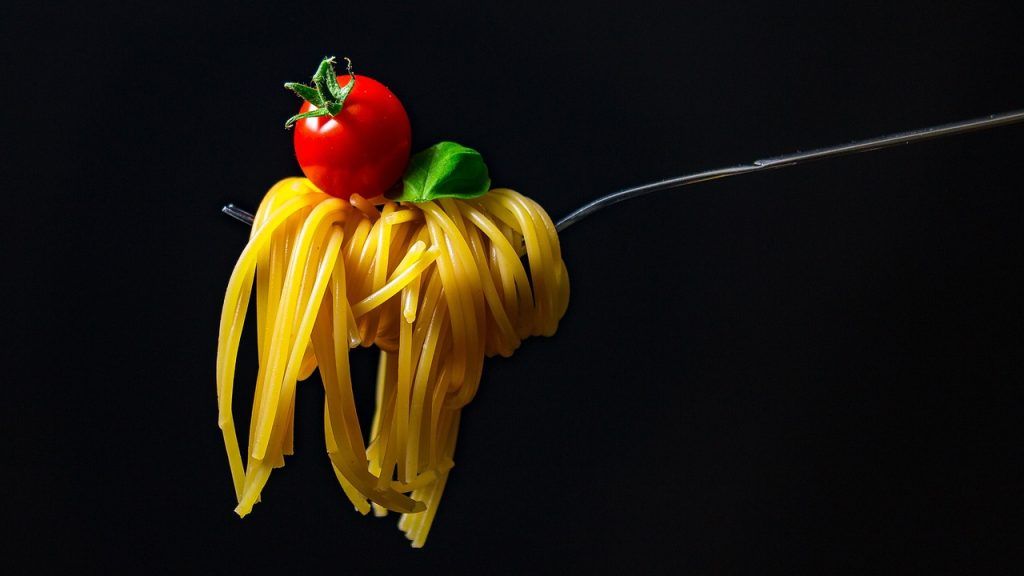 tenedor cogiendo spaghetti con un tomate cherry encima