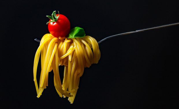 tenedor cogiendo spaghetti con un tomate cherry encima