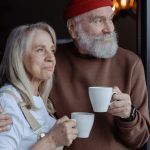 Hombre y mujer adultos sostienen taza